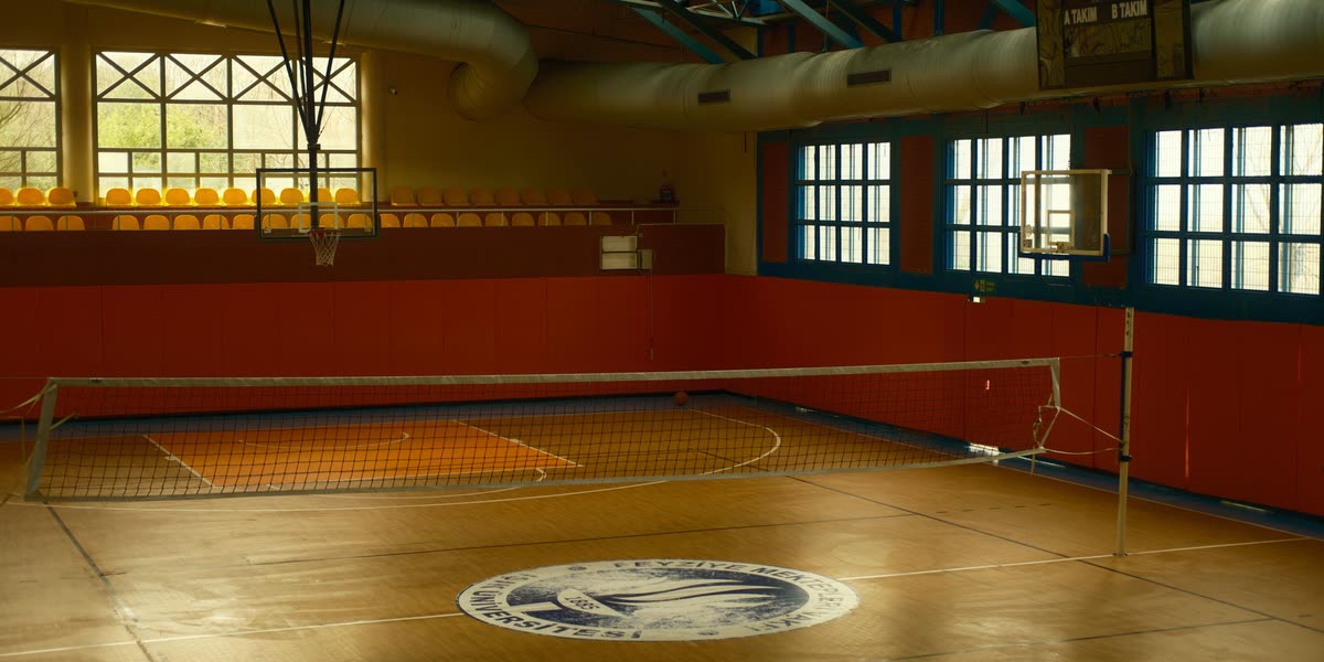 Leere Sporthalle mit Volleyballnetz und Basketballkorb